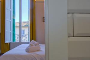una camera da letto con due asciugamani su un letto con finestra di MOTIF 26 Pistoia a Pistoia