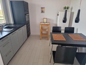 a kitchen with a table and chairs and a refrigerator at APARTAMENT NA POLNEJ in Ustka