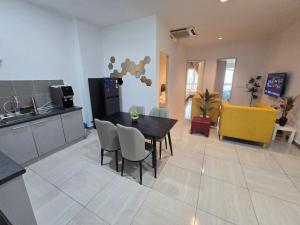 a kitchen and dining room with a table and chairs at The Octagon Ipoh City Centre Leisure Suite in Ipoh