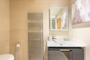 een badkamer met een wastafel en een spiegel bij Park Home near Portobello Road - Raised Ground Floor - WiFi - Washing Machine in Londen