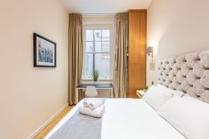 een slaapkamer met een wit bed en een raam bij Park Home near Portobello Road - Raised Ground Floor - WiFi - Washing Machine in Londen