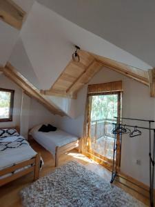 a attic room with a bed and a window at Beogradjanka mala in Zvornik