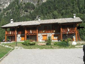 a large wooden house with a balcony on a mountain at Chalet village situated in a quiet area in Antey-Saint-André