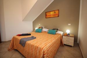 a bedroom with a bed and a dresser with a bed sidx sidx sidx sidx at 9 Nereide in San Vito lo Capo