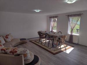 ein Wohnzimmer mit einem Tisch, Stühlen und einem Sofa in der Unterkunft Casa Inoke in Poiana Micului