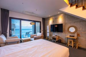 een hotelkamer met een bed en uitzicht op de oceaan bij Drama 2015 in Jeju-stad