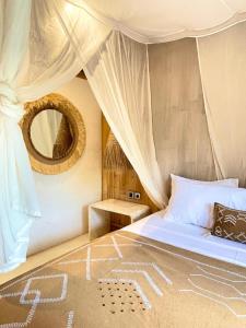 een slaapkamer met een groot bed en een spiegel bij Nusava Boutique Hotel in Nusa Penida