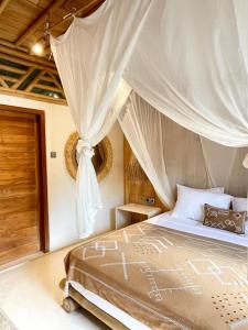 een slaapkamer met een hemelbed bij Nusava Boutique Hotel in Nusa Penida