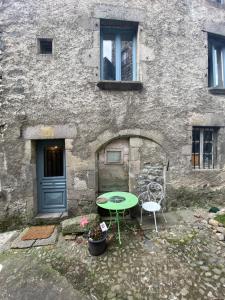 a table and two chairs in front of a building at Avélia Bonnevie in Murat