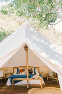 uma tenda branca com uma cama em Parada Beach Camp em El Nido