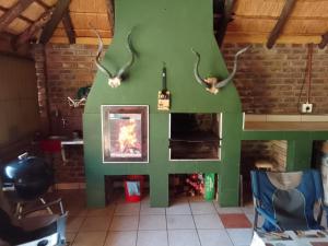 a living room with a fireplace and deer horns at Buffalo Street Cottages in Malelane