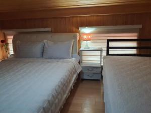 1 dormitorio con 2 camas y mesa con lámpara en Four Seasons Pension, en Suncheon