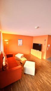 ein Wohnzimmer mit einem Sofa und einem Flachbild-TV in der Unterkunft Ferienwohnungen "Adventure Panorama" Appartement Falken Top 8 in Warth am Arlberg