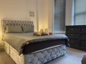 a bedroom with a large bed and a dresser at Luxury,Location and Convenience in Bournemouth