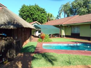 a house with a swimming pool in the yard at Buffalo Street Cottages in Malelane