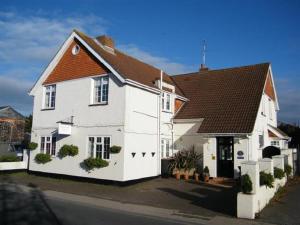 een wit huis met een bruin dak bij The Maples in Hythe