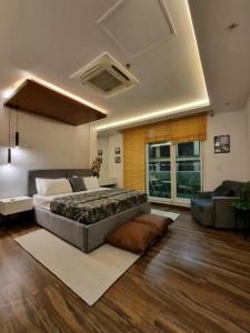 um quarto com uma cama grande e um sofá em Fun Bedroom Apartment in Gold Crest Mall and Residency DHA Lahore em Lahore