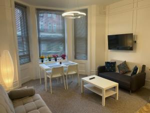 Luxury,Location and Convenience F3 في بورنموث: غرفة معيشة مع طاولة وأريكة