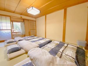 a room with three beds in a room at 奈良公園から車で約12分のお宿 