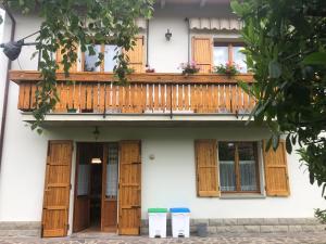 un edificio con porte in legno e balcone di Casa Natalina a Casal Fiumanese