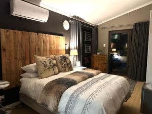 1 dormitorio con 1 cama grande y cabecero de madera en SERENITY STAY, en Bethlehem