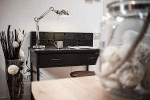 una scrivania con lampada accanto a un tavolo con un vaso di Holländer Suite a Trieste