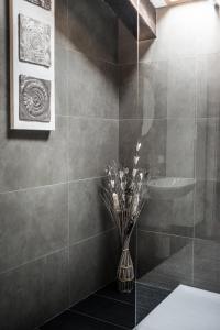 un bagno con vaso e fiori di Holländer Suite a Trieste