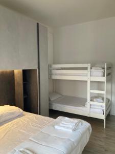 um quarto com um beliche e uma cama branca em Appartamento a 200 mt dal mare em Lido di Jesolo
