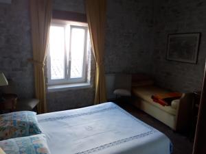 een slaapkamer met een bed en een raam bij maison grange in Sainte-Marie-de-Ré