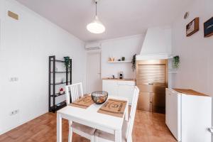 a kitchen with a white table and chairs and a white refrigerator at Acquaterra in Polignano a Mare
