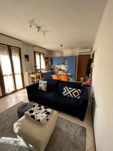 un soggiorno con un divano nero e una cucina di La casetta di Molly a Forlì