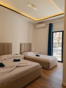 2 camas en una habitación con ventana en Vila Lazri, en Skataj