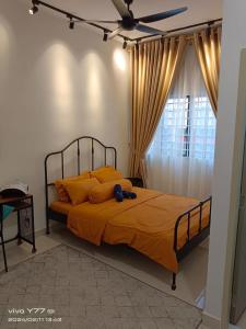 a bedroom with a bed with orange sheets and a ceiling fan at youth city residence in Nilai