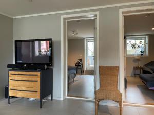 uma sala de estar com uma televisão de ecrã plano numa cómoda em Kristiansand, Bystranda 59m2, 2 soverom, 6 senger em Kristiansand