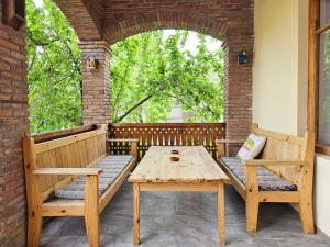 a wooden table and benches on a porch at Hotel Magdalena in Mtskheta