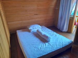 Cama en habitación con sábanas y almohadas azules en Pondok Wisata Botu Barani, en Gorontalo