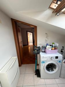 una lavanderia con lavatrice e un corridoio di La casetta di Molly a Forlì