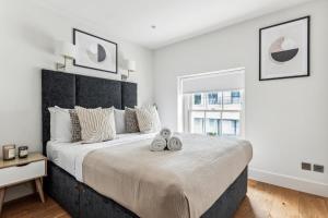 a bedroom with a large bed with two pairs of shoes on it at Modern 1BR in Central Fitzrovia - CityApartmentStay in London