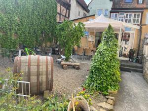 a garden with two trees and a building with a tent at Hotel Weinstube am Markt in Gerolzhofen