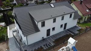 an overhead view of a white house with a roof at Marko's Wohnung in Rudersberg