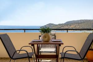 stół i krzesła z widokiem na ocean w obiekcie Anesis Apartments w miejscowości Agia Marina