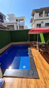 羅納瓦拉的住宿－HemPriya - 3BHK wit a Private Pool，一个带桌子和遮阳伞的游泳池