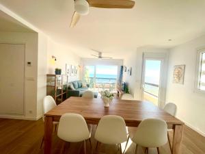 a dining room with a wooden table and white chairs at Casa Lua un espacio ideal para familias in Playa de Gandia