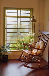 een schommelstoel in een kamer met een raam bij Góc sân và Khoảng trời 2 - Đặng Thái Thân (nguyên căn) in Xuan An