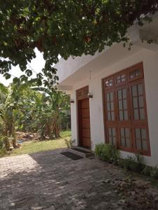 uma casa com uma porta de madeira e uma entrada de tijolos em Metro Stay em Kurunegala