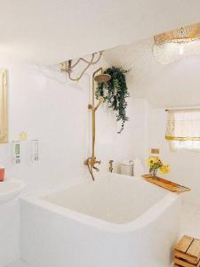 een witte badkamer met een bad en een wastafel bij Góc sân và Khoảng trời 2 - Đặng Thái Thân (nguyên căn) in Xuan An