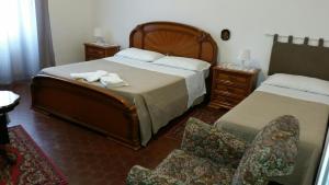 a hotel room with two beds and a chair at Il Cucù B&B in Frascati
