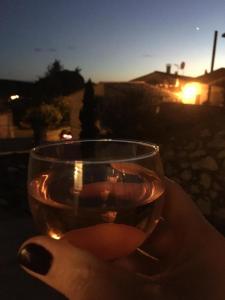 a person holding a glass of wine at sunset at La Maison de Papé in Combas
