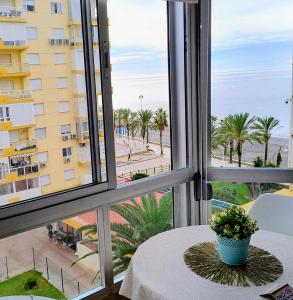 a window with a table and a view of the beach at Hoja Calá Apartment in Algarrobo-Costa