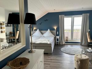 a bedroom with a bed and a large window at Hotel Restaurant Ostsee-Anker in Langballig